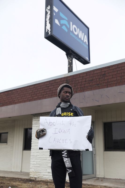 © Reuters. Wallace Mazon holds a sign protesting the Iowa Caucus outside of the Iowa Democratic Party headquarters in Des Moines