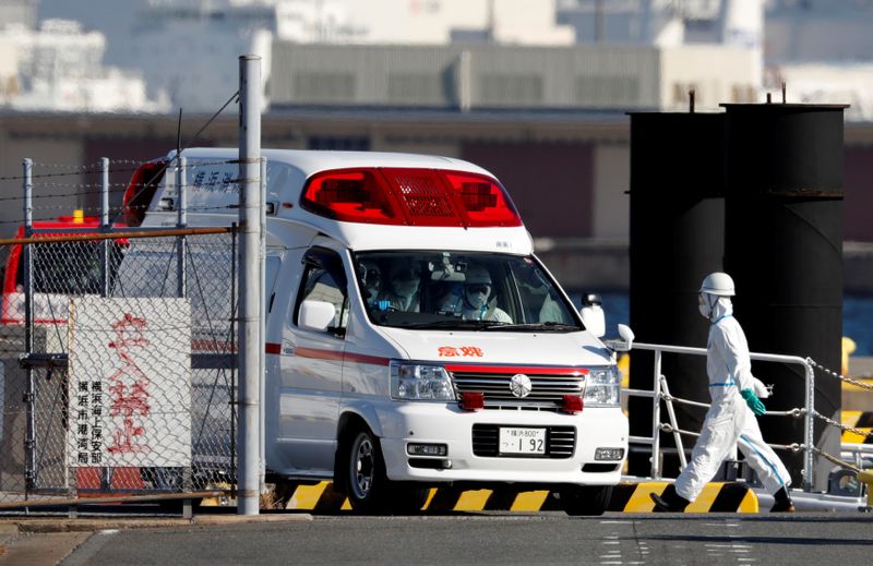 © Reuters. Ambulance workers in protective gear drive an ambulance which is believed to carry a person who was transferred from cruise ship Diamond Princess after ten people tested positive for coronavirus, at a maritime police's base in Yokohama
