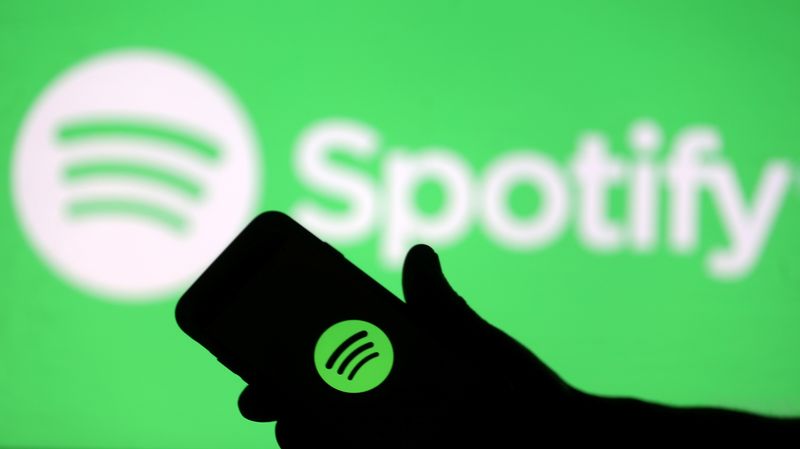 © Reuters. FOTO DE ARCHIVO: Un smartphone se ve frente a una proyección de pantalla del logo de Spotify, en esta ilustración fotográfica tomada el 1 de abril de 2018