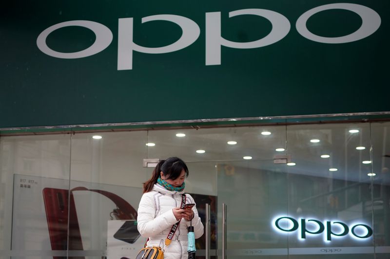 © Reuters. A woman walks by an Oppo logo at a shopping mall in Shanghai