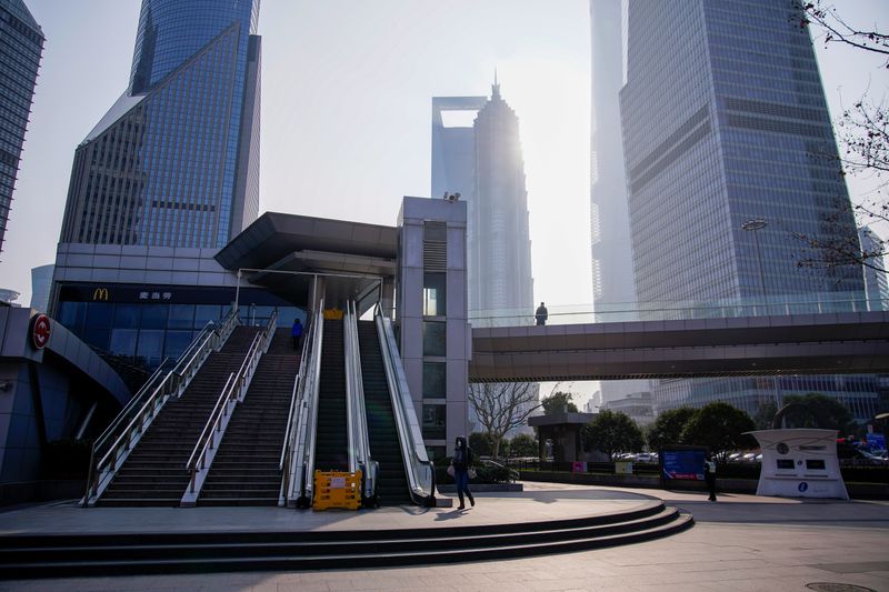 © Reuters. FILE PHOTO: People wearing masks are seen at Lujiazui financial district in Pudong, Shanghai