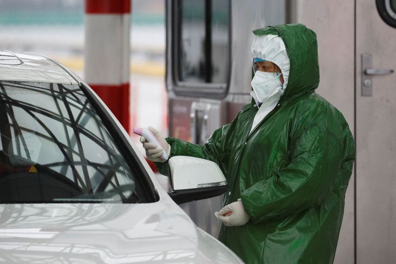 © Reuters. Un trabajador médico comprueba la temperatura de un conductor en un puesto de control mientras el país es golpeado por un brote del nuevo coronavirus en Anqing, provincia de Anhui, China, el 6 de febrero de 2020