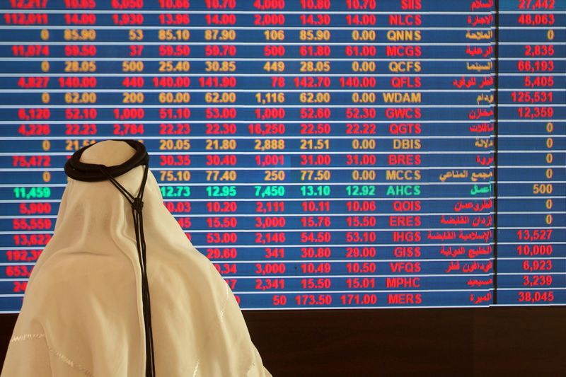 © Reuters. FILE PHOTO: Trader monitors a screen displaying stock information at Qatar Stock Exchange in Doha