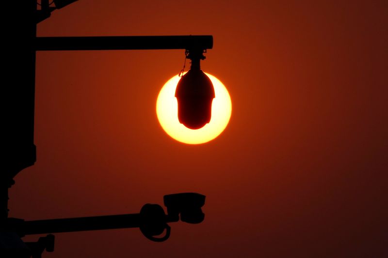 © Reuters. FILE PHOTO: Rising sun is seen behind surveillance cameras before a military parade marking the 70th founding anniversary of People's Republic of China