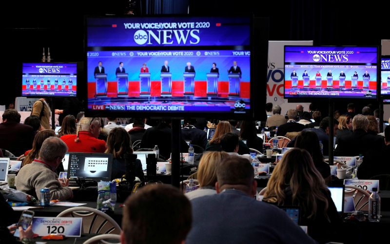 © Reuters. FILE PHOTO: Democratic presidential candidates are seen debating on video screens in the media filing center at the Democratic 2020 U.S. presidential candidates debate in Manchester