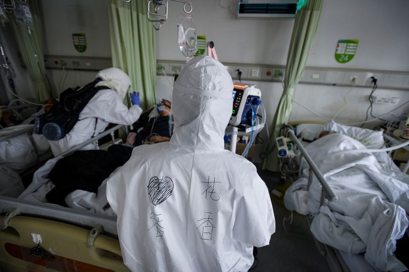 © Reuters. Personal sanitario con trajes protectores atienden a los nuevos pacientes con coronavirus dentro de una sala aislada en un hospital de Wuhan, provincia de Hubei, China