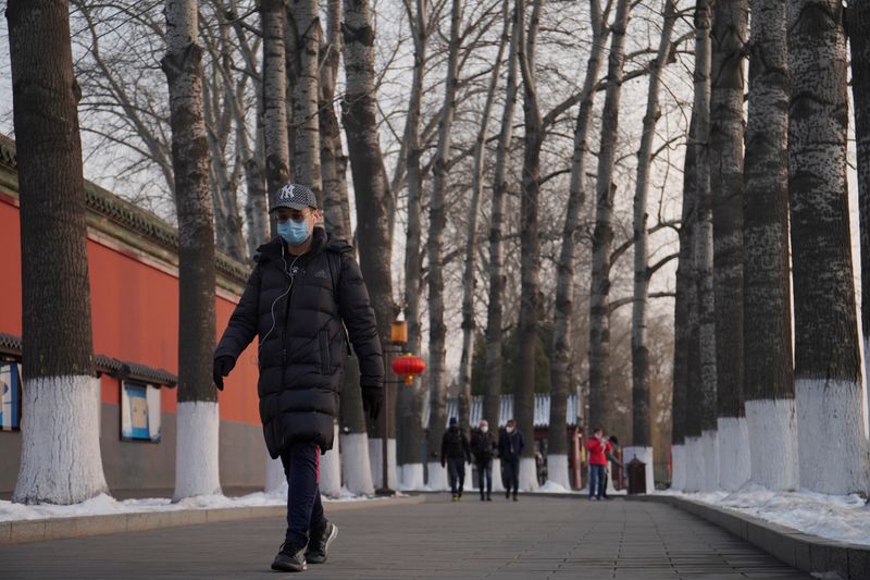 © Reuters. Man wearing a face mask walks at the Beihai Park as the country is hit by an outbreak of the novel coronavirus