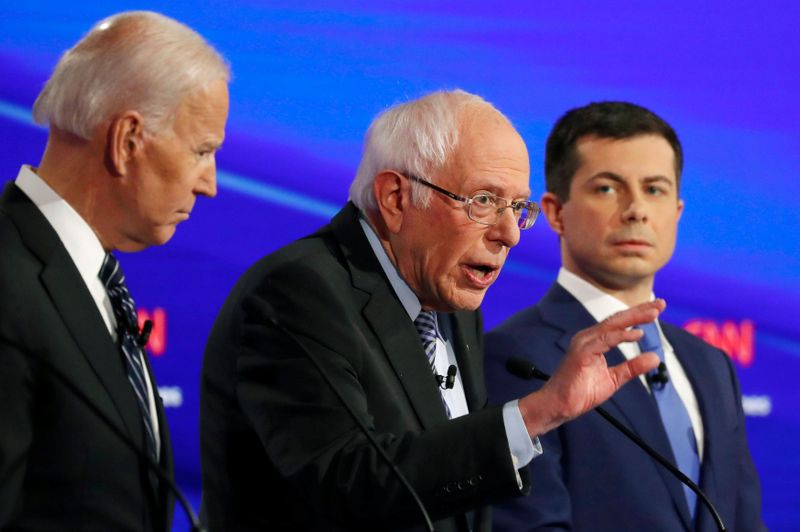 © Reuters. FILE PHOTO: Democratic 2020 U.S. presidential candidates former Vice President Joe Biden listens to Senator Bernie Sanders as former South Bend Mayor Pete Buttigieg looks on in the seventh Democratic 2020 presidential debate at Drake University in Des Moi