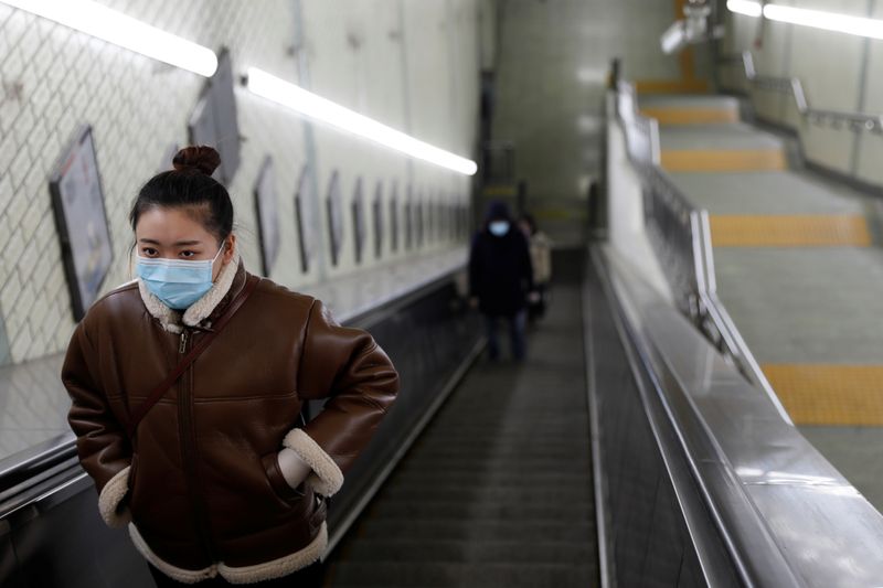 © Reuters. Mulher utiliza máscara de prevenção contra coronavírus em estação de metrô de Pequim