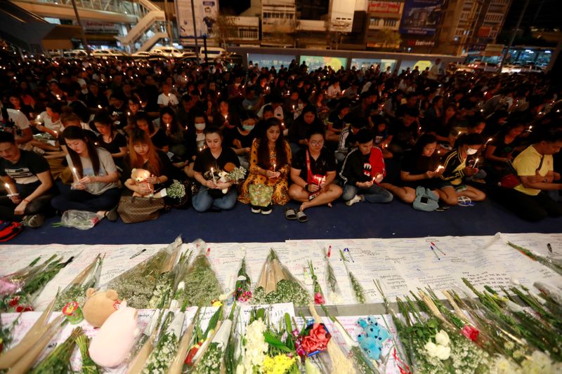 © Reuters. People gather as they pray for victims who died in a mass shooting, in front of Terminal 21 shopping mall in Nakhon Ratchasima