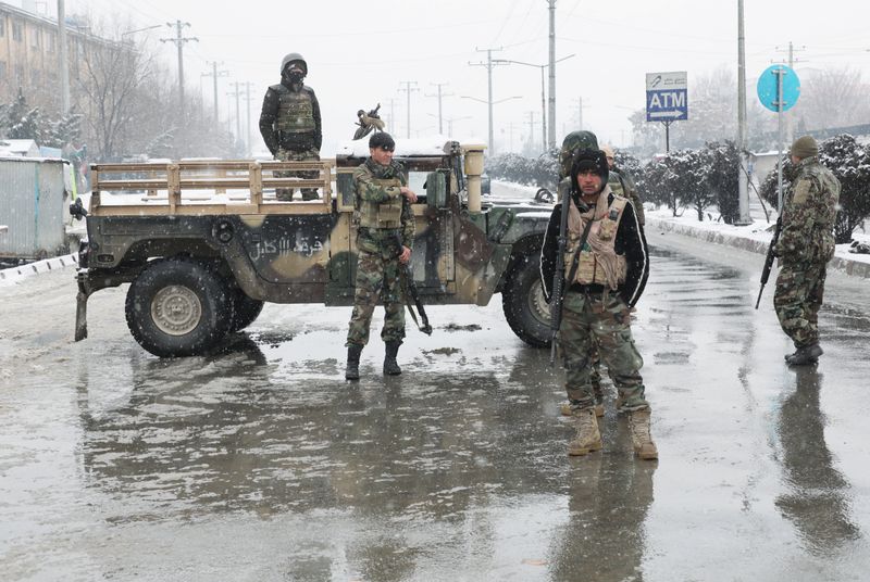 © Reuters. Afghan security forces keep watch near the site of a suicide attack in Kabul