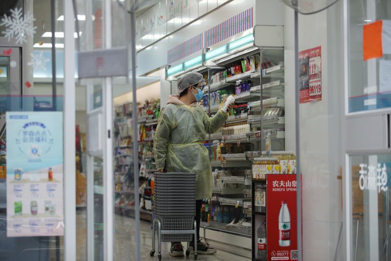 © Reuters. Worker is seen inside a convenience store following an outbreak of the novel coronavirus in Wuhan