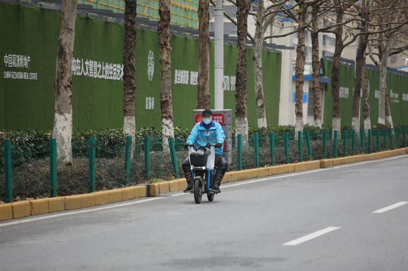 © Reuters. Delivery worker for Alibaba's Hema Fresh supermarket chain rides an electric bike following an outbreak of the novel coronavirus in Wuhan