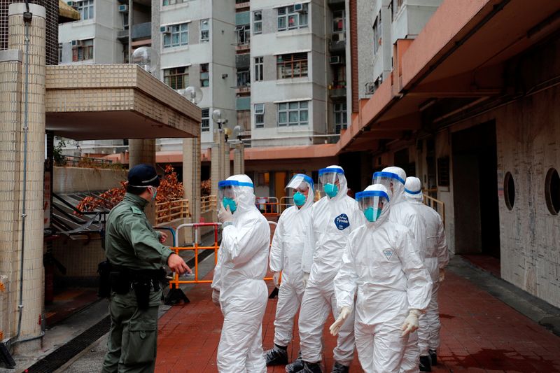 © Reuters. Police in protective gear wait to evacuate residents from a public housing building, following the outbreak of the novel coronavirus, in Hong Kong