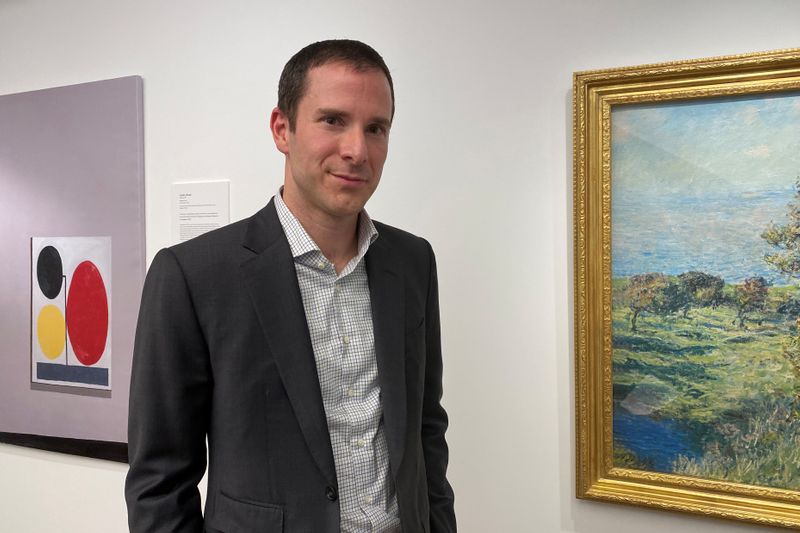 © Reuters. Scott Lynn, CEO and founder of Masterworks, poses next to artworks in New York