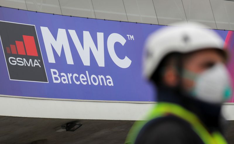 © Reuters. Employee is pictured next to the logo of MWC20 (Mobile World Congress) in Barcelona