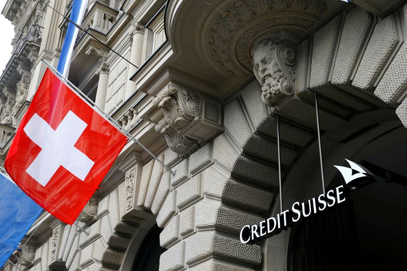 © Reuters. FILE PHOTO: Switzerland's national flag flies beside a logo of Swiss bank Credit Suisse in Zurich