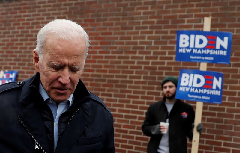 © Reuters. FILE PHOTO: A supporter for Democratic 2020 U.S. presidential candidate and former Vice President Joe Biden holds a sign as Biden leaves a polling station after a visit, on the day of New Hampshire's first-in-the-nation primary in Manchester, New Ham