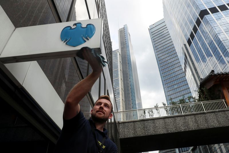 © Reuters. FILE PHOTO: A worker cleans a Barclays logo outside a bank branch in the financial district of London