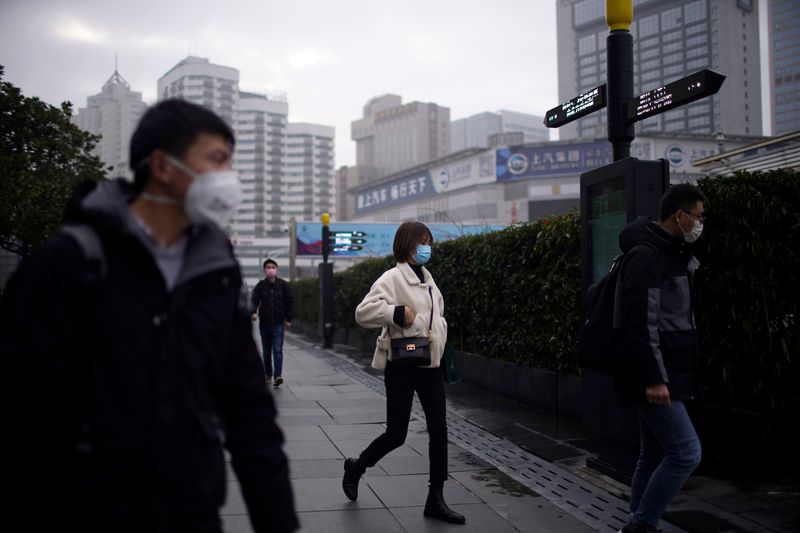 © Reuters. People wearing masks are seen at a square in Shanghai