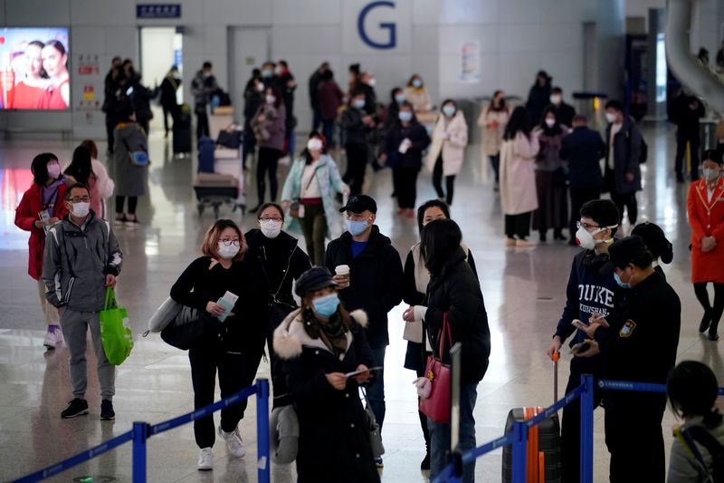 © Reuters. FILE PHOTO: FILE PICTURE: Passengers wearing masks are seen at the Pudong International Airport in Shanghai
