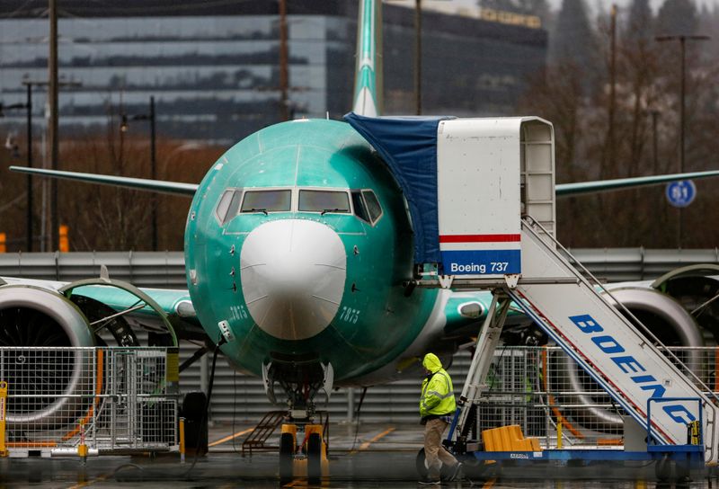 © Reuters. An employee walks past a Boeing 737 Max aircraft seen parked at the Renton Municipal Airport in Renton