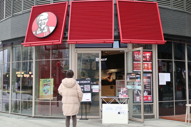 © Reuters. Customer waits to pick up her order outside a KFC restaurant as the country is hit by an outbreak of the novel coronavirus, in Chengdu