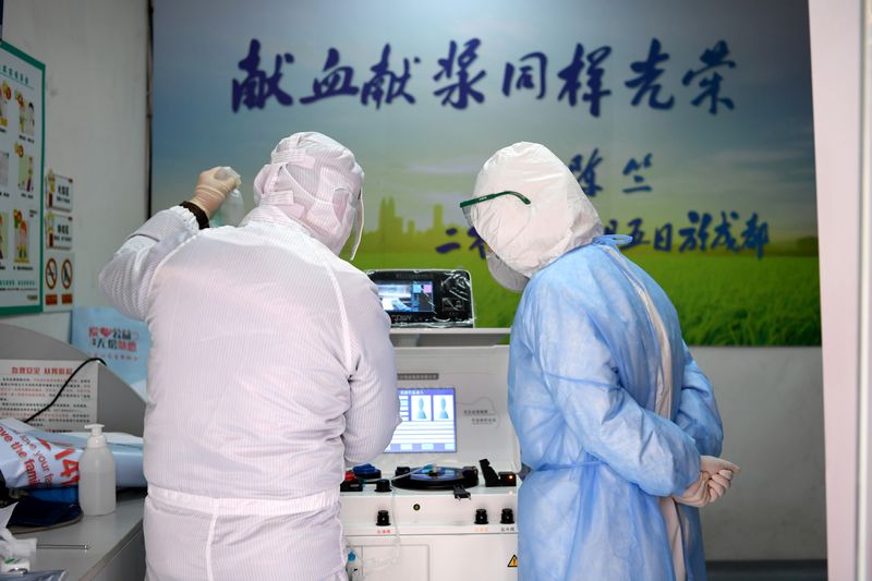 © Reuters. Medical workers in protective suits inspect equipment at a blood donation room of the Renmin Hospital of Wuhan University
