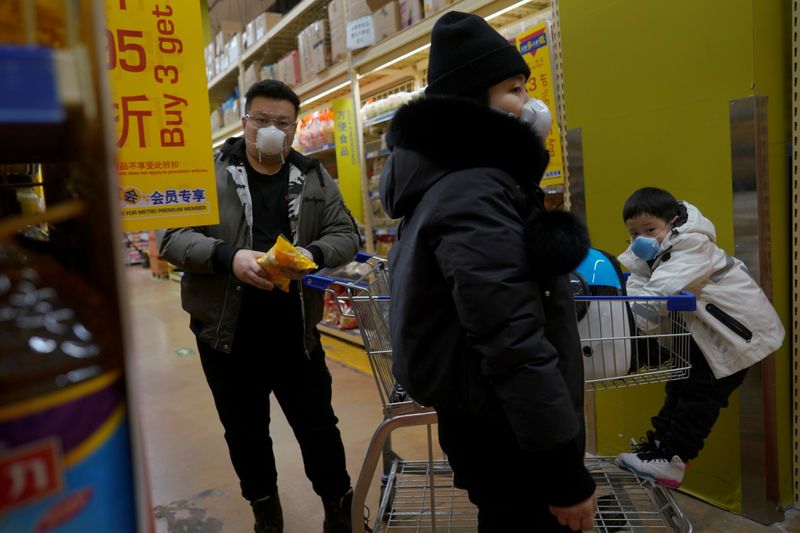 © Reuters. Customers wearing face masks shop inside a supermarket, as the country is hit by an outbreak of the novel coronavirus, in Beijing
