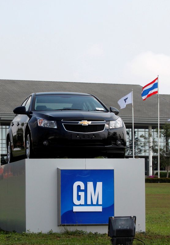 © Reuters. FILE PHOTO: The Thai national flag and a car are displayed vehicle in front of the General Motors (GM) plant in the Eastern Seaboard Industrial Estate in Rayong province February 22, 2011