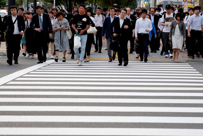 © Reuters. FILE PHOTO: Pedestrians make their way in a business district in Tokyo