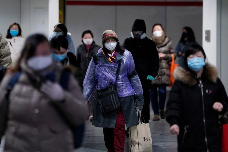 © Reuters. Personas con máscaras faciales caminan por una estación de metro en Shanghái