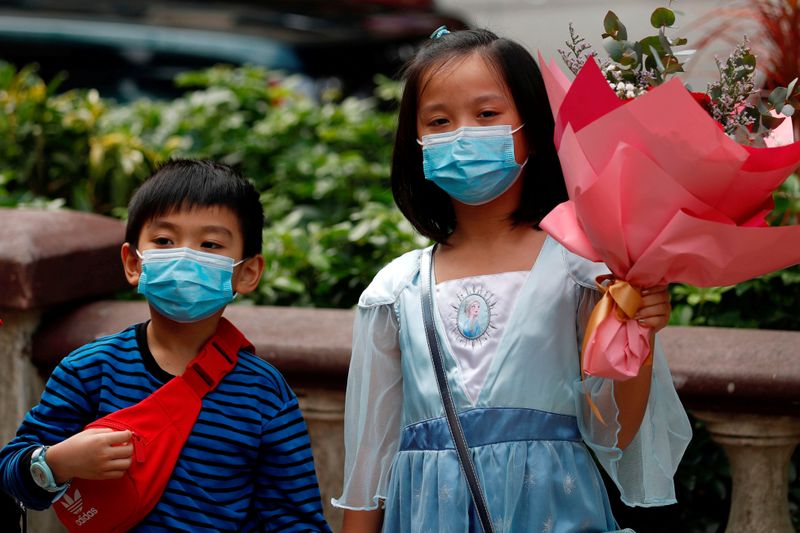© Reuters. Crianças usam máscaras de proteção em Hong Kong