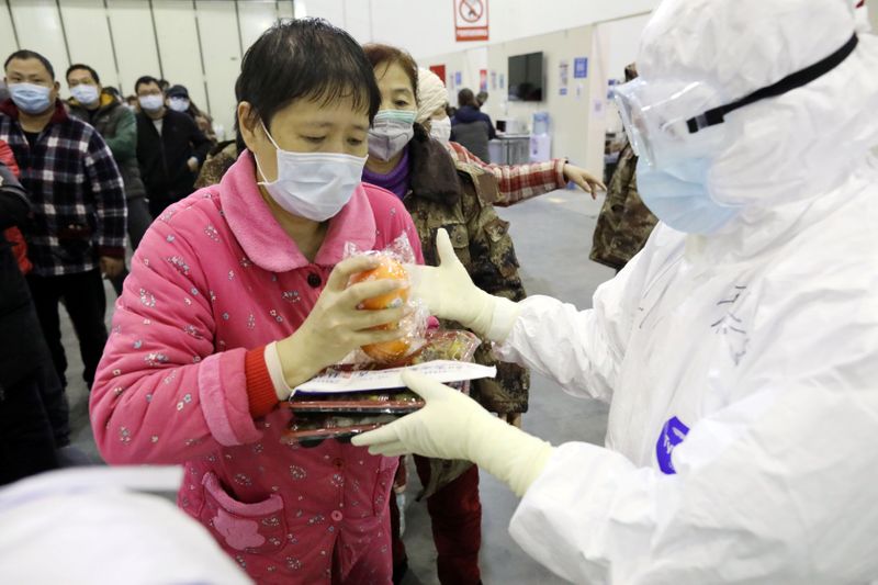 © Reuters. Paciente recebe almoço em centro de convenções de Wuhan transformado em hospital improvisado para combater surto de novo coronavírus