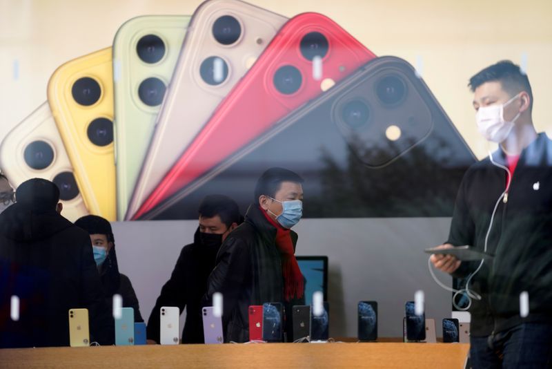 © Reuters. FILE PHOTO: People wearing protective masks are seen in an Apple Store, as China is hit by an outbreak of the new coronavirus, in Shanghai