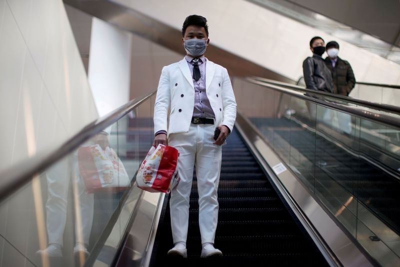 © Reuters. Un hombre con mascarilla sube por una escalera mecánica en la Estación de Ferrocarril Hongqiao de Shangai el último día de la fiebre por el viaje del Festival de Primavera, mientras el país es golpeado por un brote del novedoso coronavirus, en Shanga