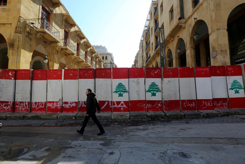 © Reuters. FILE PHOTO: A man walks past concrete barriers in Beirut