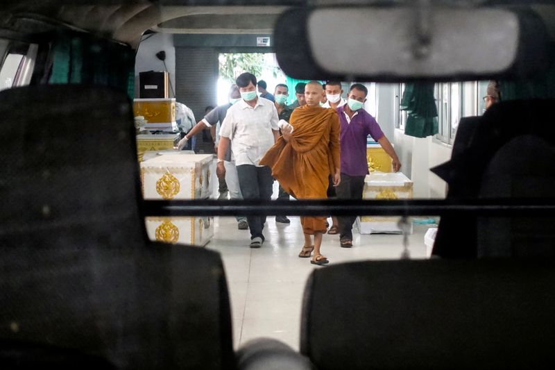 © Reuters. FILE PHOTO: A buddhist monk and rescue workers carry a body of a victim of a gun battle involving a Thai soldier on a shooting rampage at a hospital, in Nakhon Ratchasima
