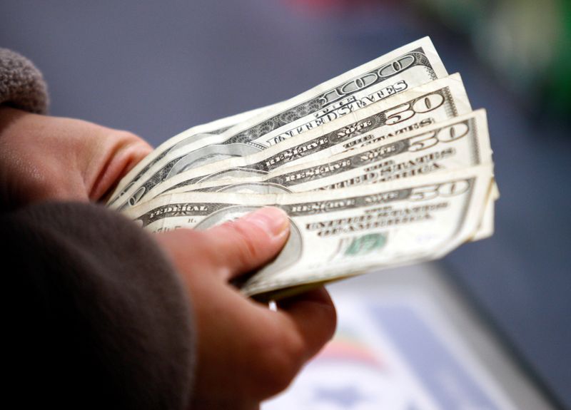 © Reuters. FILE PHOTO: A customer counts her money at the register of a Toys R Us store on the Thanksgiving Day holiday in Manchester