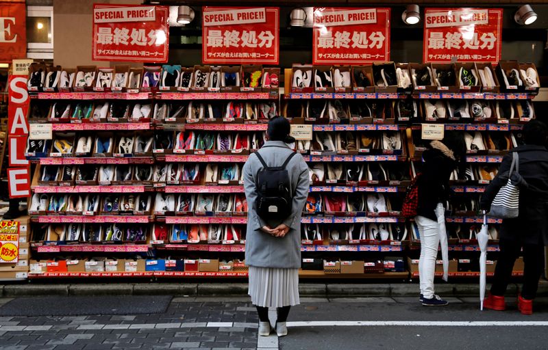© Reuters. FILE PHOTO: A woman looks at shoes on sale at an outlet store in Tokyo's shopping district