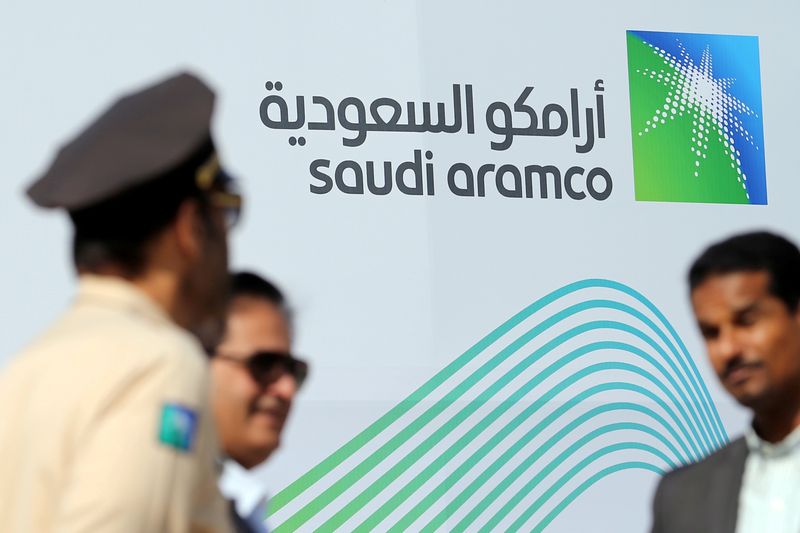 © Reuters. FILE PHOTO: Logo of Aramco is seen as security personnel stand before the start of a press conference by Aramco at the Plaza Conference Center in Dhahran
