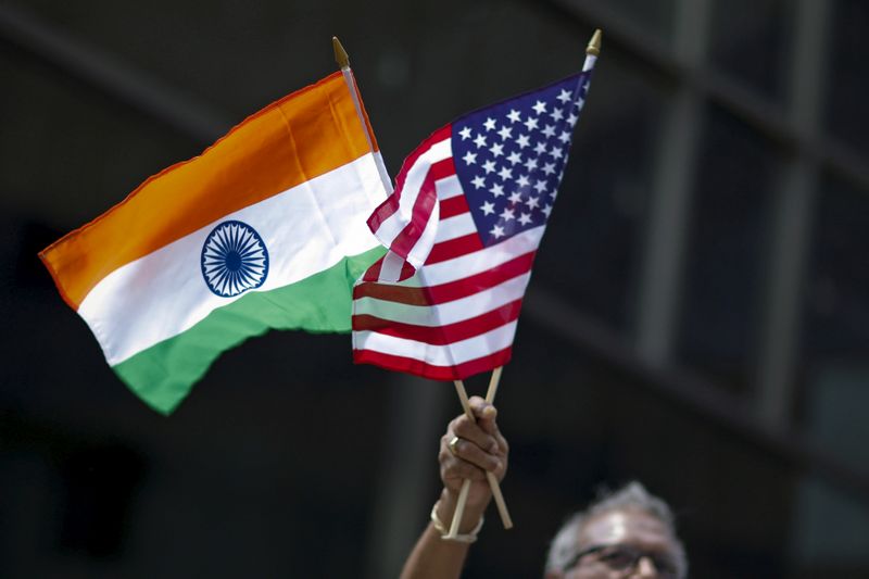 © Reuters. FILE PHOTO: Man holds the flags while people take part in the 35th India Day Parade in New York