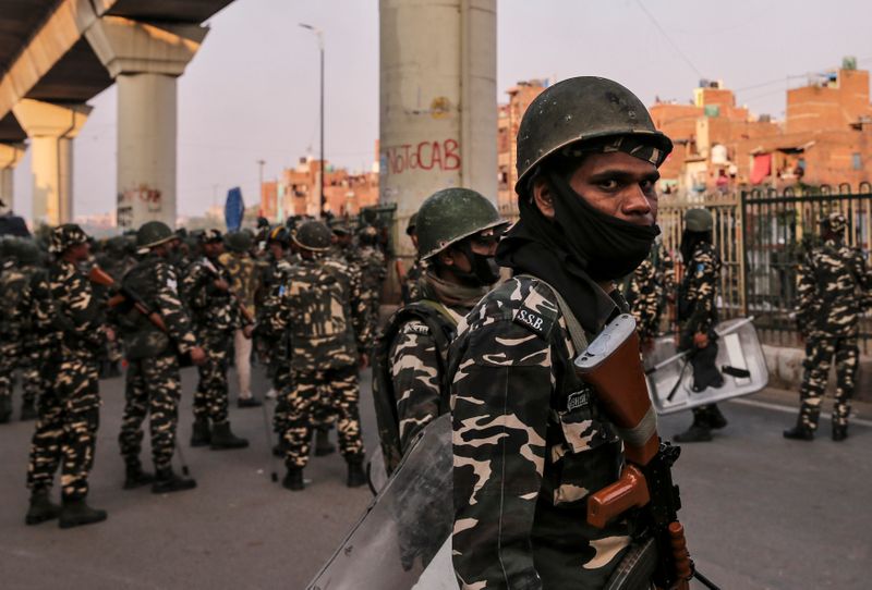 © Reuters. Paramilitary troops patrol in a riot affected area after clashes erupted between people demonstrating for and against a new citizenship law in New Delhi