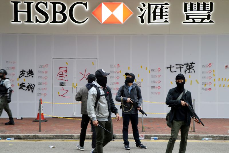 © Reuters. FILE PHOTO: Armed undercover police officers guard a vandalized HSBC bank branch in Wan Chai during demonstrations on the New Year's Day in Hong Kong