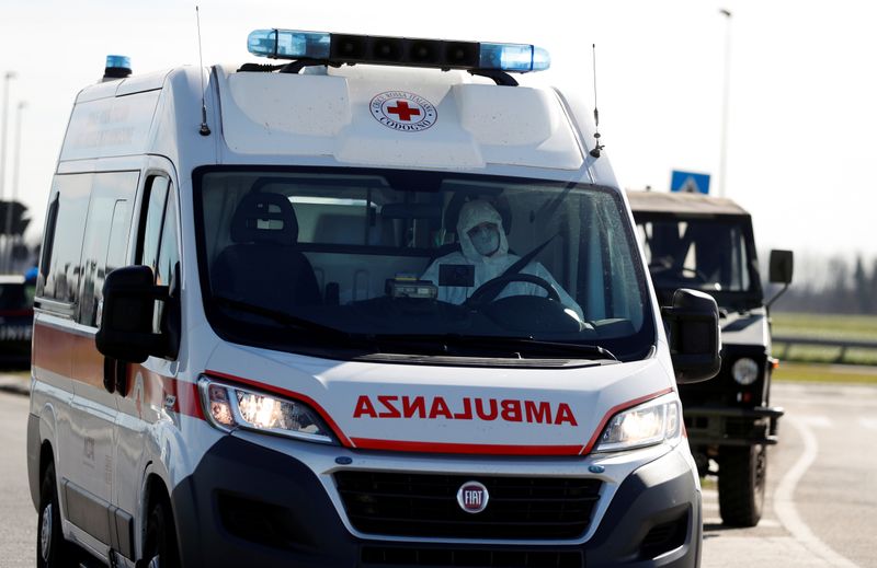 © Reuters. A man wearing a protective face mask drives an ambulance as he leaves the cordoned area in a "check-point six", few kilometers from the small town of Castiglione d'Adda