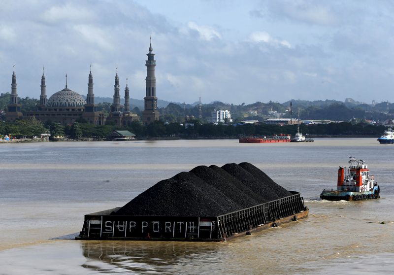 © Reuters. FILE PHOTO: A tug boat pulls a coal barge along the Mahakam River in Samarinda