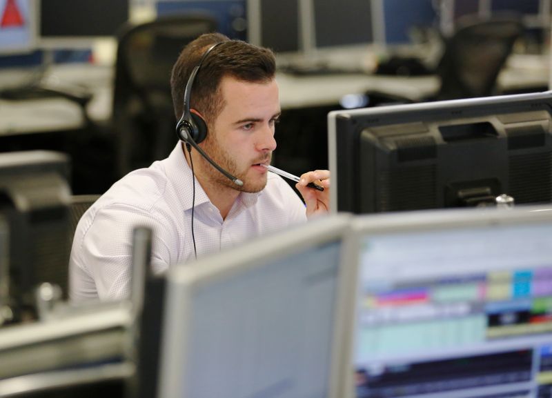 © Reuters. A trader sits at his desk at IG Index in London