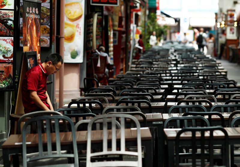 © Reuters. Un promotor de un restaurante espera a los clientes en el barrio chino en gran parte vacío mientras el turismo disminuye debido al brote de coronavirus en Singapur