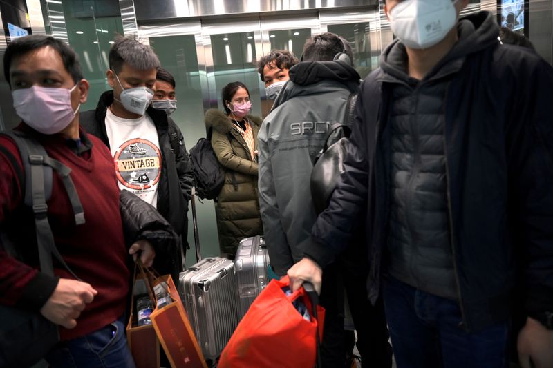 © Reuters. Pessoas de máscara no aeroporto Pequim Daxing