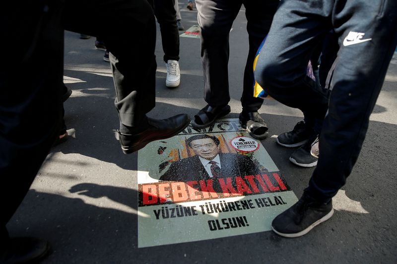 © Reuters. FILE PHOTO: Ethnic Uighur demonstrators step on a poster with an image of Chinese President Xi Jinping during a protest against China in front of the Chinese Consulate in Istanbul
